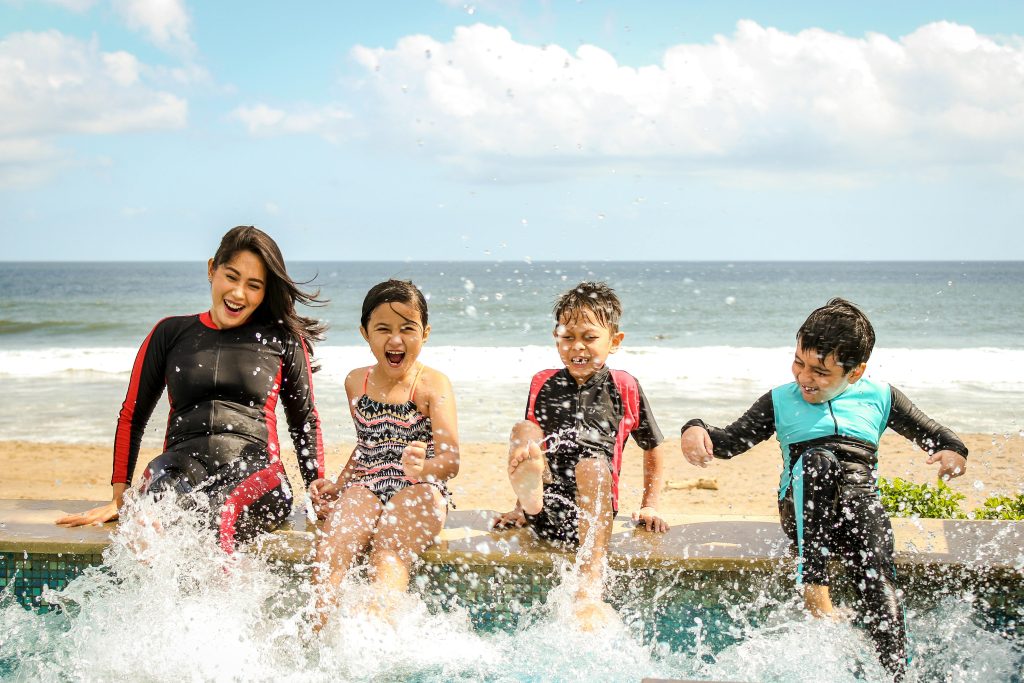 Family at the beach spending time together surfing with the kids