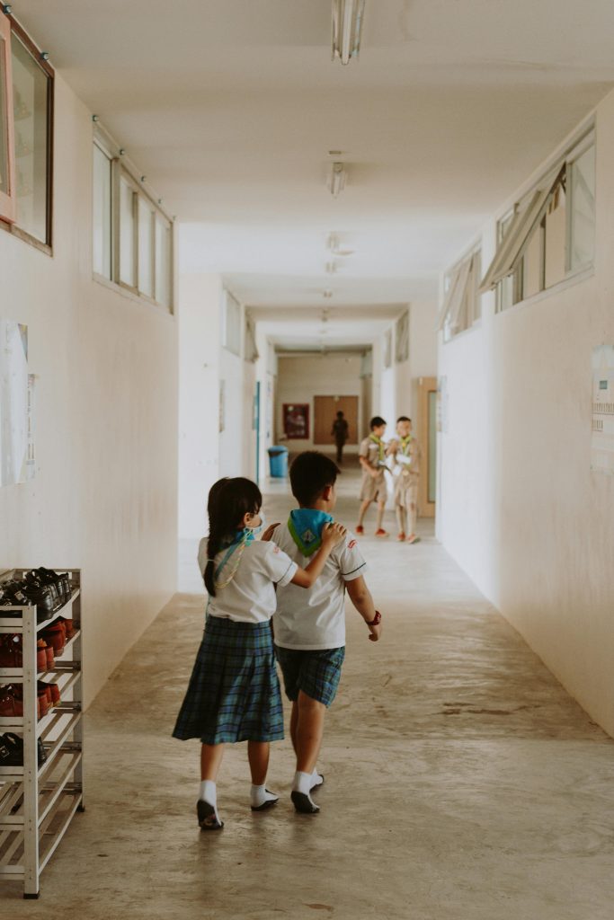 A boy and a gril in school-uniforms in the school corridor