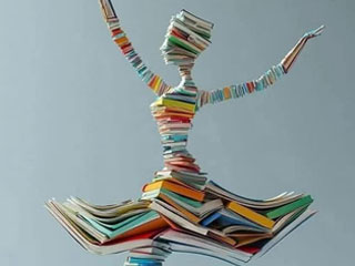 All colour of books in the shape of a dancer with a tutu shaped shirt, two outstretched arms and she's wearing a turban-style head-covering.